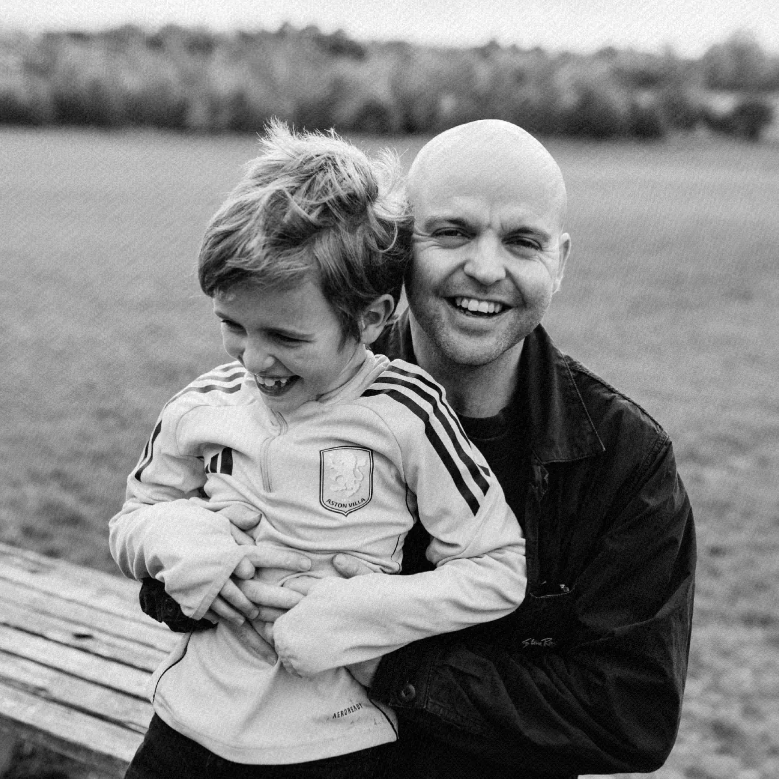 Black and white photo of Dan laughing outdoors